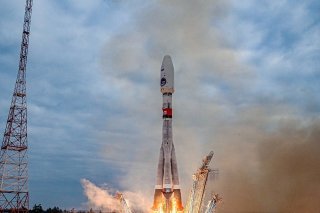 La fusée Soyouz s'est élevé dans un panache de fumée et de flammes sous un ciel gris.